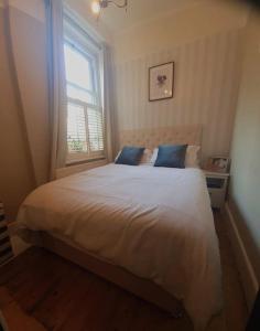 a bedroom with a large white bed with a window at Charming luxury 1 bed apartment in London