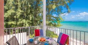 una mesa y sillas en un balcón con vistas al océano en Cayman Paradise Villa #1, en Sand Bluff