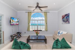 a living room with a couch and a ceiling fan at Cayman Paradise Villa #1 in Sand Bluff