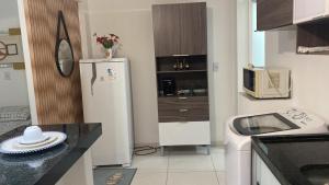 a small kitchen with a refrigerator and a microwave at Apartamento central 2B in Montes Claros