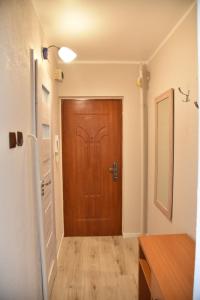 korytarz z drewnianymi drzwiami w pokoju w obiekcie Kawalerka Górnośląska w Kaliszu