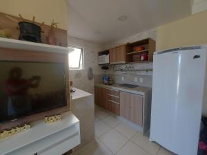 uma cozinha com uma televisão de ecrã plano e um frigorífico em Aldeia das Aguas Quartier em Barra do Piraí
