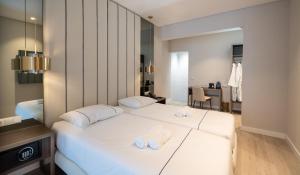 a hotel room with two beds with towels on them at AMMA Lisboa Hotel in Lisbon
