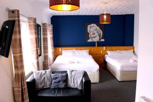 een slaapkamer met 2 bedden en een blauwe muur bij Henson Hotel Pleasure Beach in Blackpool