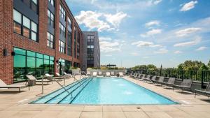 une piscine avec des chaises et un bâtiment dans l'établissement Logan Square 2br w pool lounge gym nr L CHI-869, à Chicago