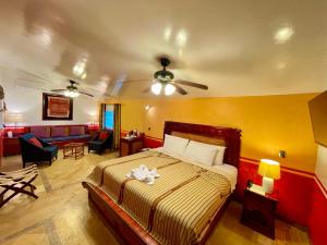 a bedroom with a bed and a living room at Hotel Boutique Quinta Chanabnal in Palenque