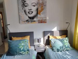 a bedroom with two beds and a picture on the wall at Os Heem in Wittem