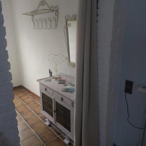 baño con tocador con espejo y suelo de baldosa en Os Heem en Wittem