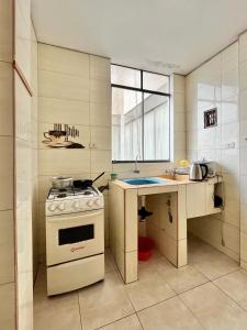 a small kitchen with a stove and a sink at CASA LARA - Departamento equipado, 2 dormitorios in Lima