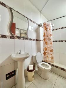 a bathroom with a sink and a toilet and a mirror at CASA LARA - Departamento equipado, 2 dormitorios in Lima