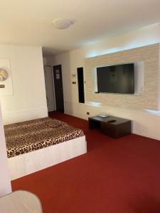 a hotel room with a bed and a flat screen tv at Karra Hotels in Voluntari +32 photos