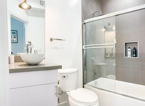 Baño blanco con aseo y lavamanos en Spacious Townhouse in Mid City - CR4-WIN, en Los Ángeles
