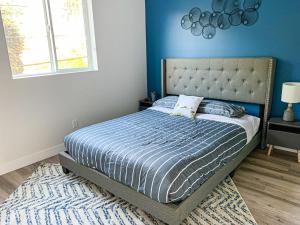 1 dormitorio con 1 cama con pared azul en Spacious Townhouse in Mid City - CR4-WIN, en Los Ángeles