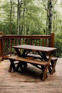 - une table de pique-nique en bois assise sur une terrasse en bois dans l'établissement Tuckaseegee @ Sky Ridge Yurts, à Bryson City