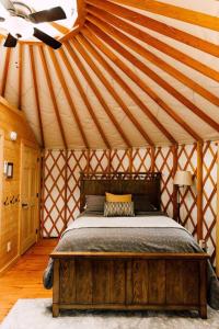 a bedroom with a wooden bed in a yurt at Tuckaseegee @ Sky Ridge Yurts in Bryson City