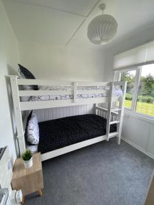 a white bunk bed in a room with a window at Bay view chalet, 28 Sea Valley in Bucks Mills