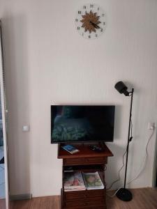 una stanza con televisore e orologio sul muro di Os Heem a Wittem