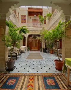 an empty courtyard with a large building with trees at RIAD LALLA ZINEB in Rabat