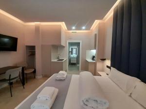 um quarto com uma cama branca e 2 toalhas em GBH Hotel-Apartamentos Estrella de Mar em Benidorm