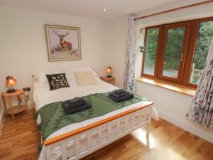 a bedroom with a white bed in a room with windows at Rudbaxton Water in Haverfordwest