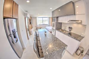 - une cuisine avec un long comptoir dans une pièce dans l'établissement Cruz del Mar - Panoramic Rooftop Pool Views Near Marina, à La Cruz de Huanacaxtle