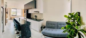 - une cuisine et un salon avec un canapé et un comptoir dans l'établissement Cruz del Mar - Panoramic Rooftop Pool Views Near Marina, à La Cruz de Huanacaxtle