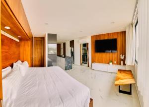 une chambre avec un lit blanc et une télévision dans l'établissement Cruz del Mar - Panoramic Rooftop Pool Views Near Marina, à La Cruz de Huanacaxtle 46 autres photos