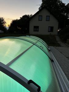 a green swimming pool with a house in the background at Moderní dům s bazénem a saunou, Žďárské vrchy in Malá Losenice