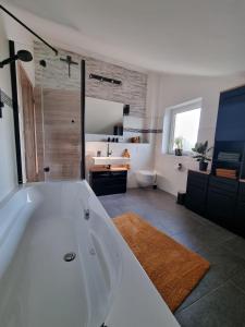 uma casa de banho com uma grande banheira branca e um lavatório. em Ambiente Feriendomizil em Weilerswist