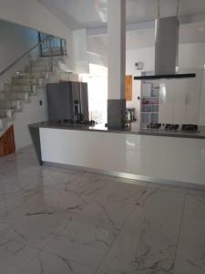a large white kitchen with a counter and stairs at CABAÑA MANANTIAL DE DIOS in Turbo