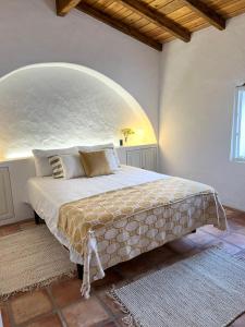 um quarto com uma cama grande e um arco por cima em Casa das Chaminés em Santo António do Baldio