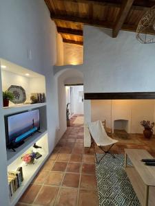 uma sala de estar com uma televisão e uma mesa em Casa das Chaminés em Santo António do Baldio