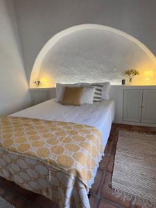 um quarto com uma cama com um arco por cima em Casa das Chaminés em Santo António do Baldio