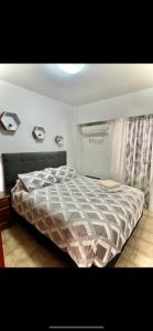 1 dormitorio con cama con edredón en Monoambiente en Córdoba