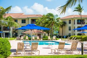 ein Resort mit einem Pool mit Stühlen und Sonnenschirmen in der Unterkunft Georgetown Villas #113 in Dog City