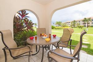 a table and chairs on a patio with a view of a yard at Georgetown Villas #113 in Seven Mile Beach