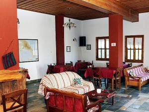 una habitación con mesas y sillas y una habitación con mesas y sillas en Guesthouse Rousis, en Zagora