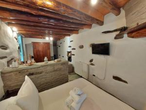 a bedroom with a bed and a sink in a room at Η Μικρή Ελβετία της Άνδρου est1900 The Writer's Retreat in Andros