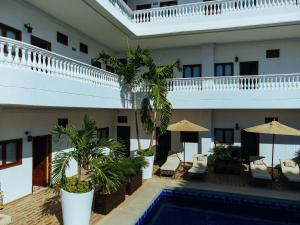 a hotel with a swimming pool and chairs and umbrellas at Hotel Abitti in Taganga