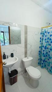 a bathroom with a white toilet and a sink at Hotel talú tayrona in El Zaino