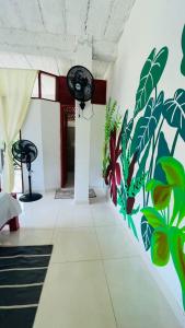 Habitación con un mural de plantas en la pared en Hotel talú tayrona, en El Zaino