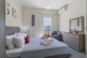 una camera con letto, cassettiera e specchio di Enchanted Sunlit Villa Retreat 1 a Isthmia