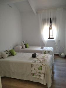 a white bedroom with two beds and a lamp at Finca El Pilar in Madridejos