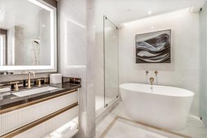a white bathroom with a tub and a sink at AZUR Legacy Collection Hotel in Vancouver