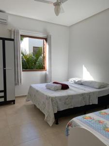 a bedroom with two beds and a window at Apartamento 102 no Vivendas do Serrano em Lençóis in Lençóis