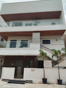 Un edificio con palmeras delante. en F2 Home Stay, en Tirupati
