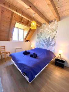 Saint-MametにあるLes trois chalets - jardin terrasse 7 personnes - Saint Mamet Luchonのベッドルーム1室(青い大型ベッド1台付)