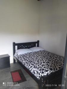 um quarto com uma cama com um edredão preto e branco em Altos del Reposo Casa Campestre em Pueblo Bello