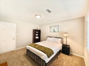 ein Schlafzimmer mit einem großen weißen Bett in einem Zimmer in der Unterkunft Tranquil Oasis in Houston