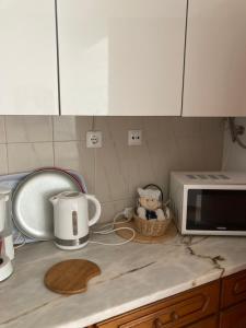 a kitchen counter top with a microwave oven and a counter top at Casa Praia do Sul in Ericeira